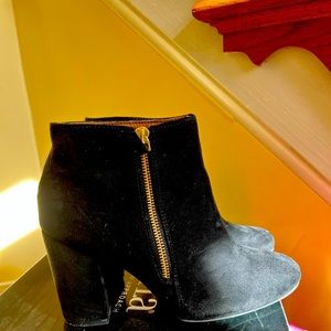Black suede boots with golden zipper.